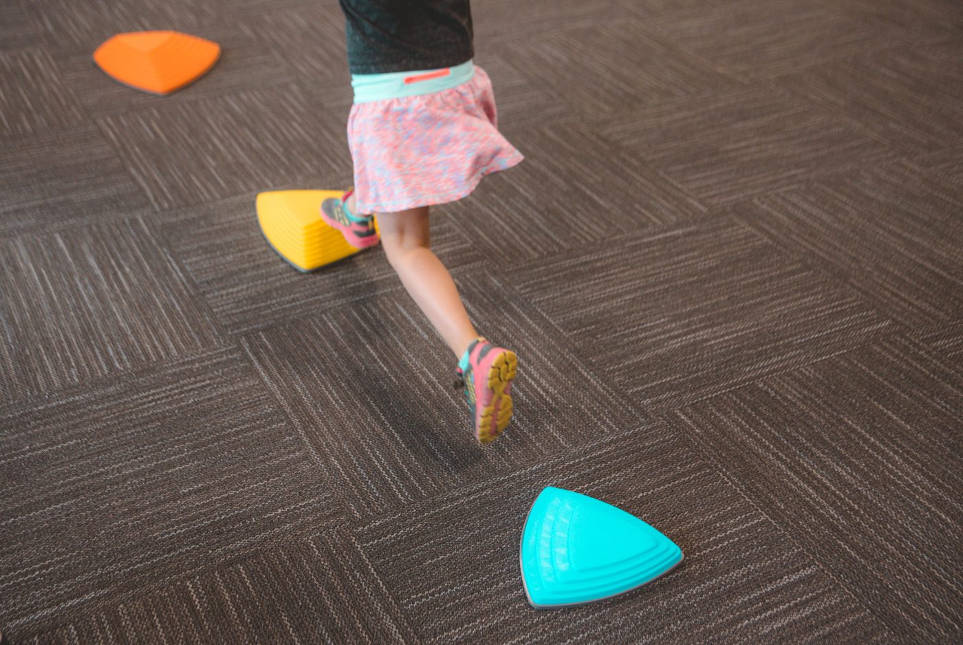 Child jumping from stepping stone to stepping stone