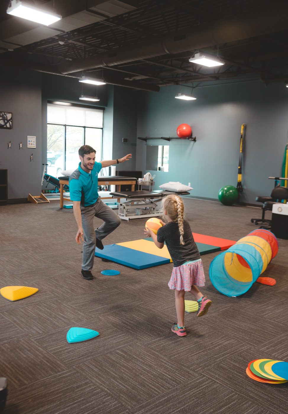 Child and therapist standing on one leg